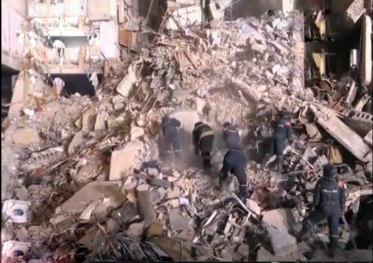 救援人员在天然气爆炸部分倒塌的公寓大楼进行救援